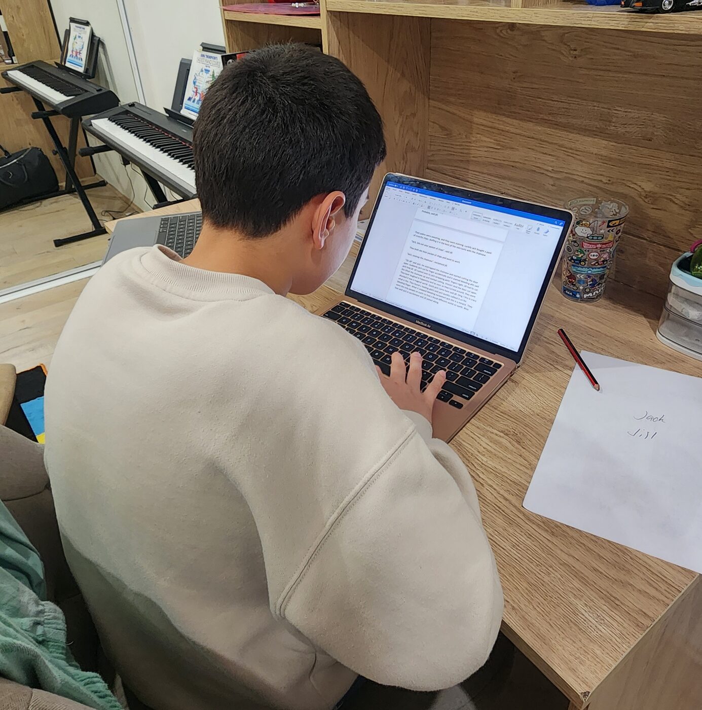 A student typing an English creative writing task on a laptop during a Rene's Academy session